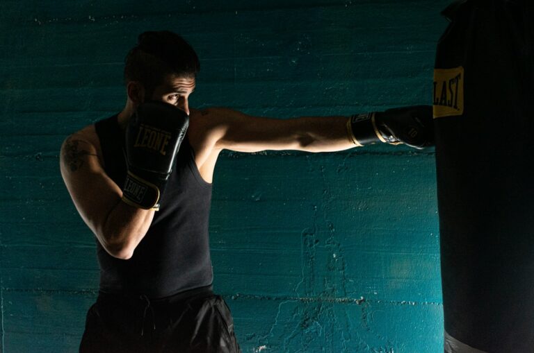 man in black tank top and black shorts wearing black boxing gloves